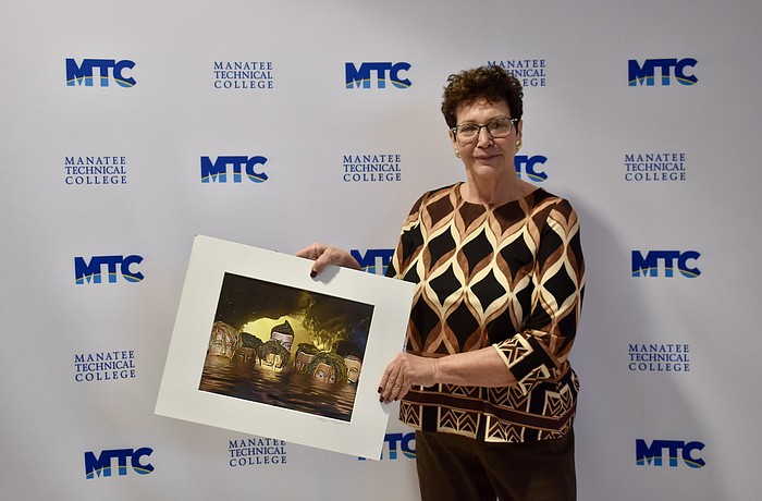 Conference Chair Katherine De Young shows off a winning image. She created the photo using mannequin heads. It was featured in the 2019 "Embracing our Differences" exhibit in Sarasota.