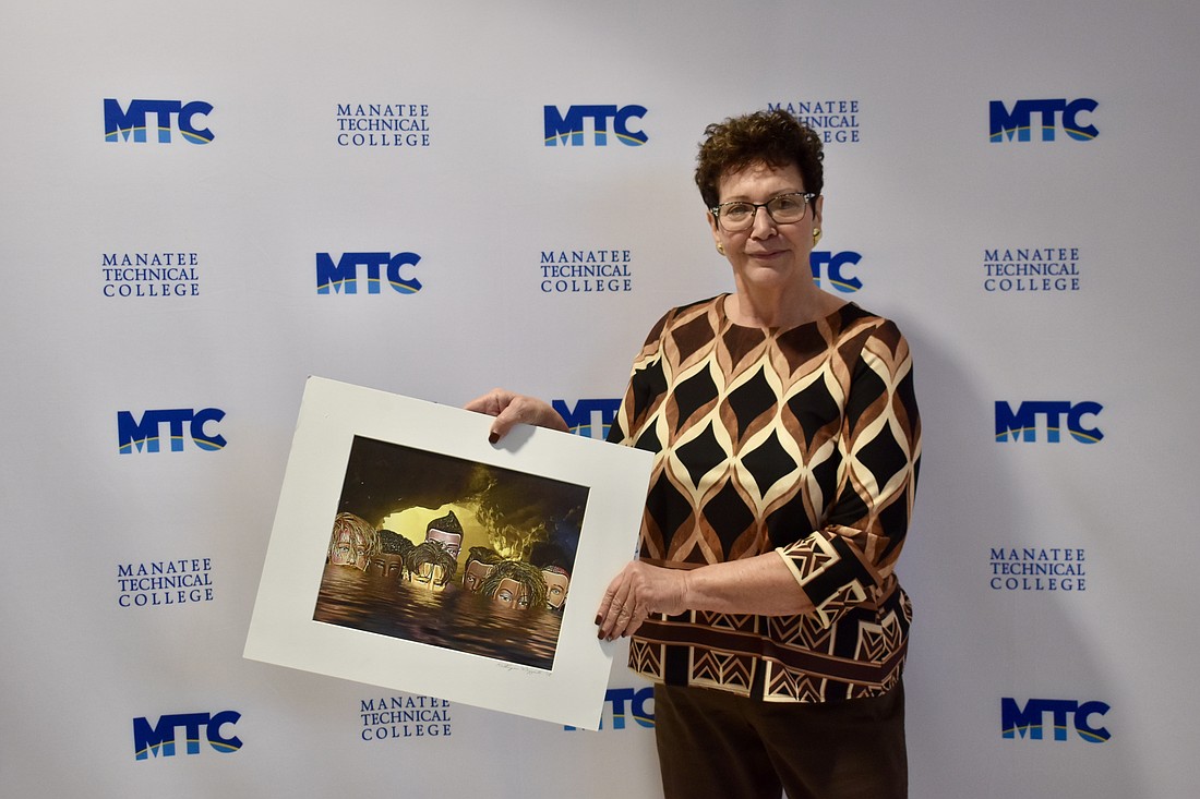 Conference Chair Katherine De Young shows off a winning image. She created the photo using mannequin heads. It was featured in the 2019 "Embracing our Differences" exhibit in Sarasota.
