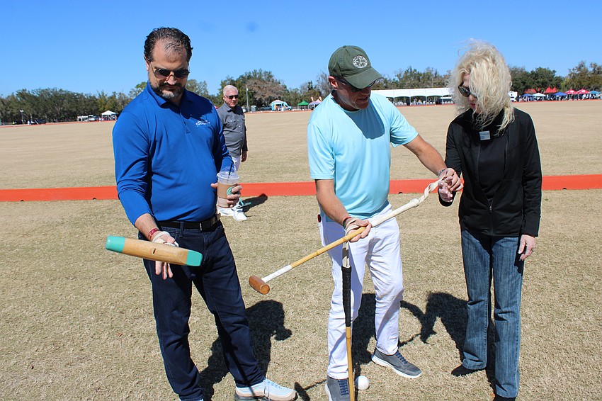 Lakewood Ranch Community Foundation Board Members Keith Pandeloglou (left) and Nyda Bittmann-Neville (right) get a polo lesson from Mark Mulligan at Polo with the Pros Feb. 8.