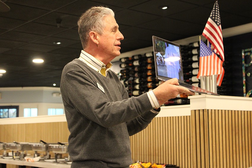 Kiwanis Club of Longboat Key Club past president Michael Garey shares a snapshot of how the Lawn Party evolved over the years during a check presentation on Feb. 5 to the Children's Guardian Fund.