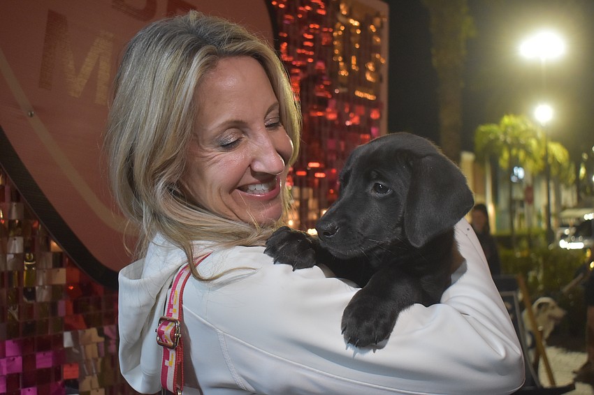 Sarasota's Angela Ruddyy came to Barks & Brews to get kisses and cuddles from puppies and she got just that from 2-month-old Sweetpea who is available for adoption at Nate's Honor Animal Rescue Center.