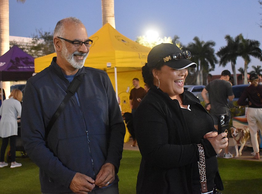 Sarasota's K Naran and Lyndie Naran get the attention of Coco and Zoey, their Australian labradoodles, for a photo. They say Barks & Brews is a great event to support Nate's Honor Animal Rescue Center while also getting their own dogs out to socialize.