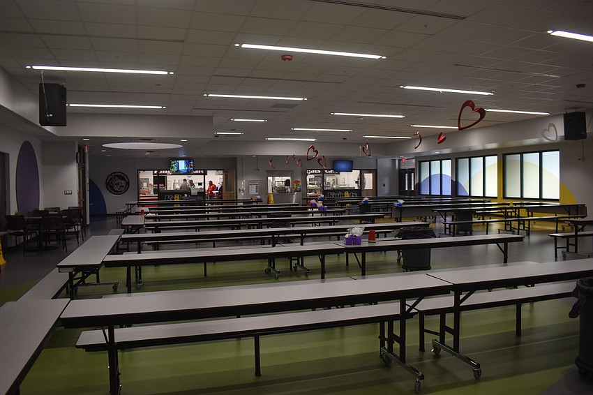 The cafeteria is now one big open room that was previously divided in two.  The stage size was increased for student use and a new bathroom was also added. The pops of color represent the different buildings around the campus.