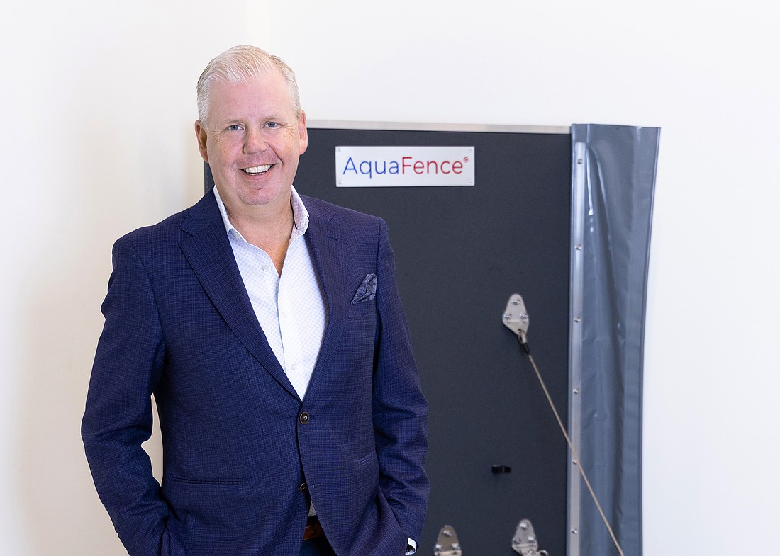 Patrik Hansson with an example of an AquaFence panel at the Norwegian flood protection company's Tampa office.