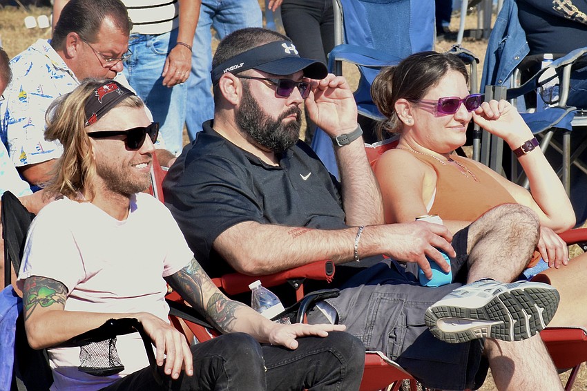 Kyle Kauffman, his brother Brian Kauffman and Brian's wife Toni Kauffman listen to live music.