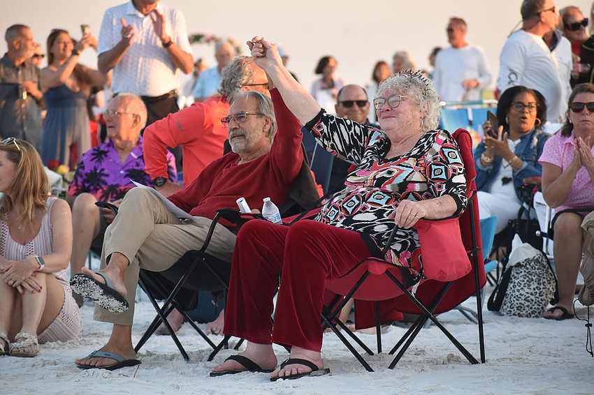 Patrick Hinchliffe and Marge McCarthy raise their hands due to being among the couples celebrating 50 or more years together.