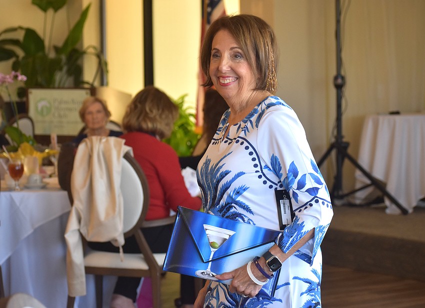 Pat Reinhart models a blue and white look by Darci's boutique during the Passion for Fashion show for the Palm Aire Women's Club.