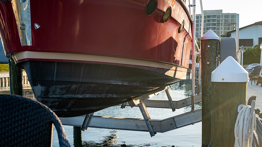 Jay and Lynne Plager installed a bow-shaped lift to avoid hitting sediment that gathers around the pilings while lowering their boat into the canal.