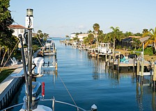 Boat lifts flank each side of the canal in a Country Club Shores neighborhood. The town of Longboat Key is preparing to enact a continuous canal maintenance program that would include flat fees and ad-valorem assessments for residents.