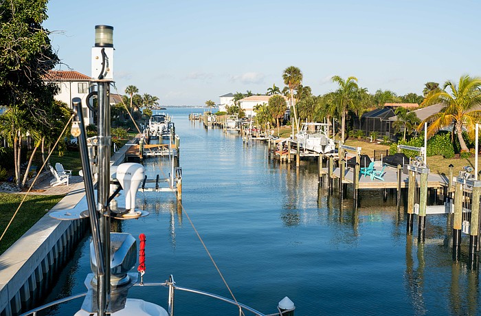Boat lifts flank each side of the canal in a Country Club Shores neighborhood. The town of Longboat Key is preparing to enact a continuous canal maintenance program that would include flat fees and ad-valorem assessments for residents.