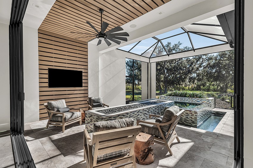An expansive outdoor living area, complete with spa, offers views of ancient oak trees.