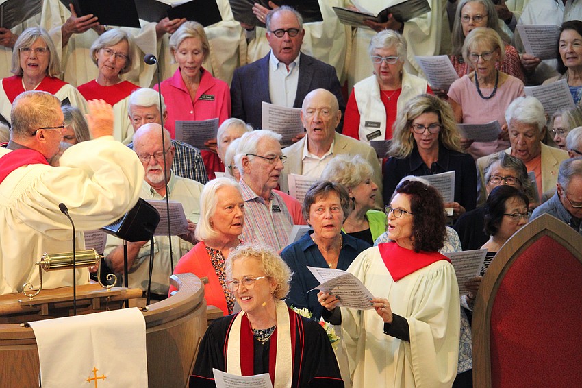 With a wave of the arms, Director of Music Robert Romanski sets the 130-member choir in motion.