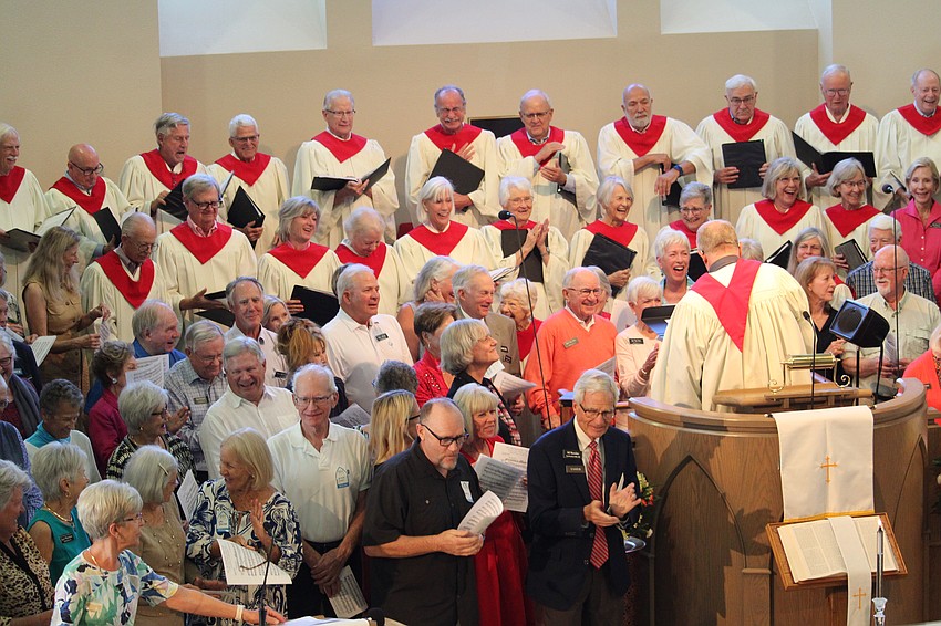 Community members applaud after successfully bringing together more than 100 people to sing with the Christ Church choir.