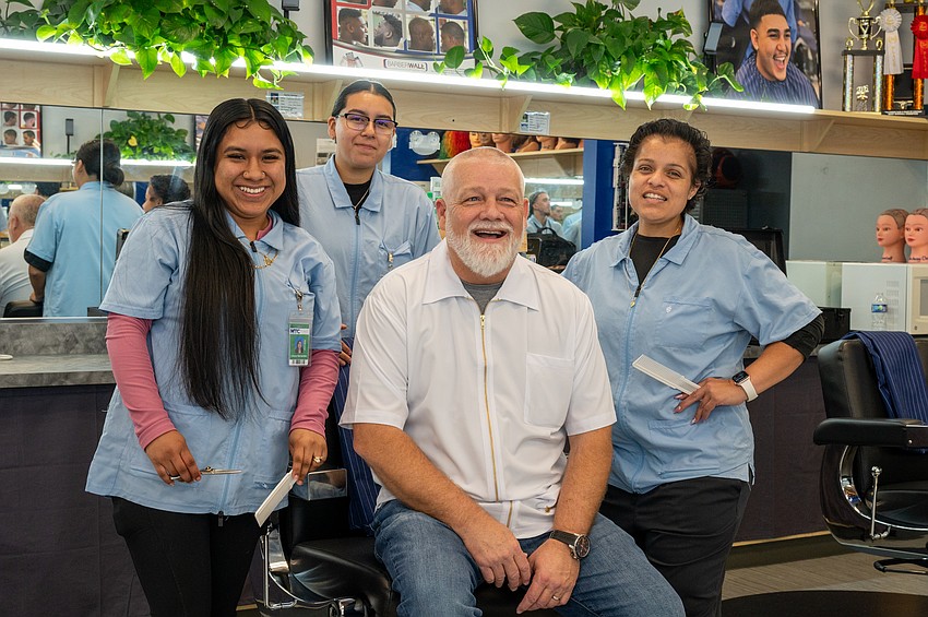 Three MTC barbering students with instructor Shane Lindergren seated: Instructor Shane Lindergren shares a laugh with students Lilly Hernandez, Esperanza Castillo, and Rosie Cervantes inside MTC’s bustling Fusion Barbershop.