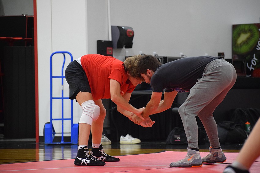 Luke Ladle (left) practices hand fighting on the mat. The sophomore boasts a 25-4 record, as of Feb. 17, earned in the 120-pound weight class.