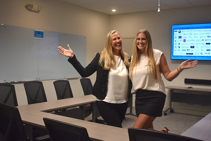 Melissa Pandeloglou and her daughter Madison McNally stand in the large conference room, which has access to a 85 inch HDTV with HDMI connections for board meetings, trainings or lectures.