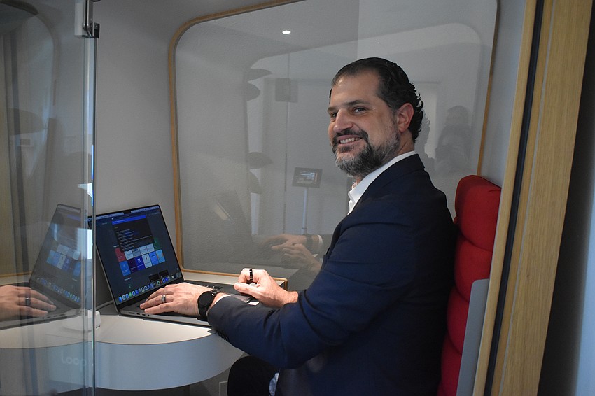 Keith Pandeloglou, the founder of Cowork LWR, sits in the phone booth located in the lobby that allows for clients who might not have their own office to make calls with some privacy.