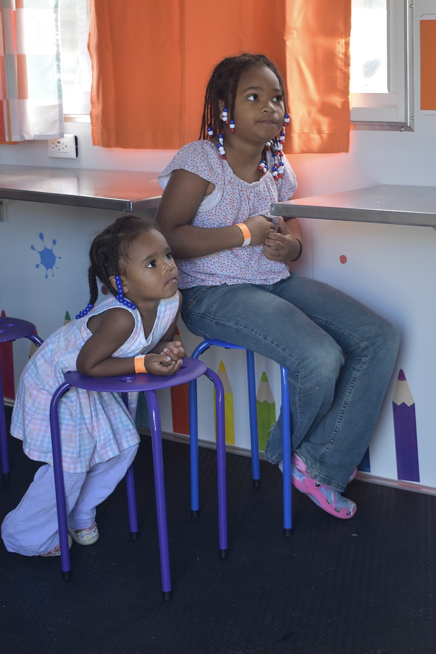 Preschooler Brooklynn Moss and third grader Lydia Moss watch a movie in the Sarasota Police Department's Sarasota Learning Center.