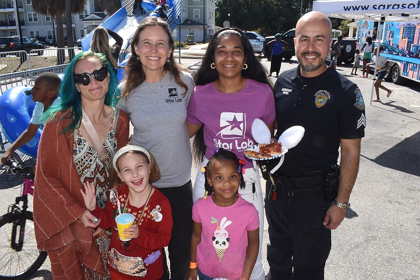 Jessie Giles and her daughter Luna Giles, third grade, Founder and Head of chool Alison Rini, Kindergartener Amiyla Muhammad and her mother Ebony Muhammad, and Sergeant Luis Paris.