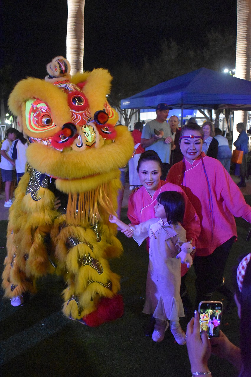 Weizhen Jiang Wolf and Yuhong Wan of Zen Rhythm Dance Group, along with their young friend Mohan Chen, socialize after all of the performances at the Lunar New Year Celebration.