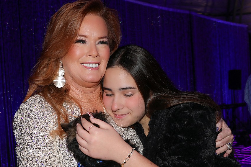 Terri K0aluber gets a hug from Daliany Leon, 16, whose wish was a trip to Paris. Her wish was granted last year in this very spot.