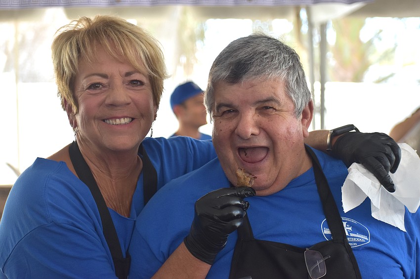 Thelma Hunter and Spiro Anthopolos are volunteering by making gyros, but can't help but grab a taste themselves.