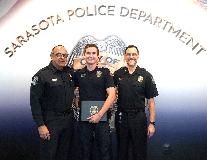 Sarasota Police Officer and Life Saver Award recipient Shane Gaines is flanked by Police Chief Rex Troche (left) and Deputy Chief Scott Mayforth.