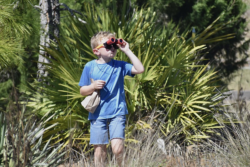Emmett Hoaglin, 7, goes birding on a trail outside the Sarasota Audubon Society building.