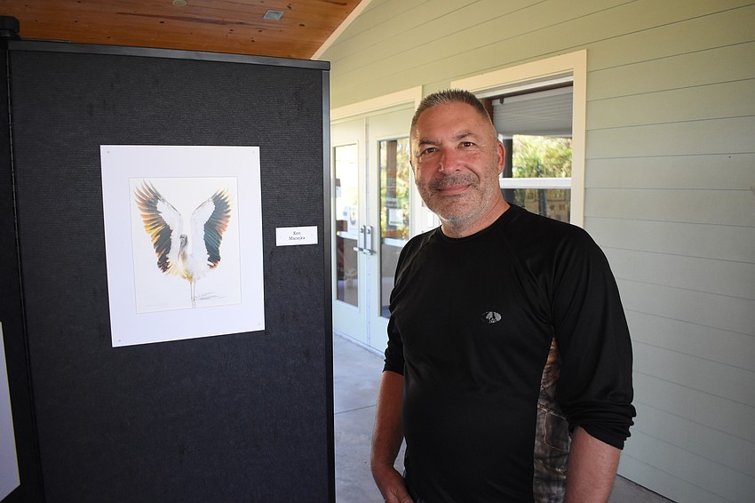 Ken Macejka poses with his photo of a wood stork.