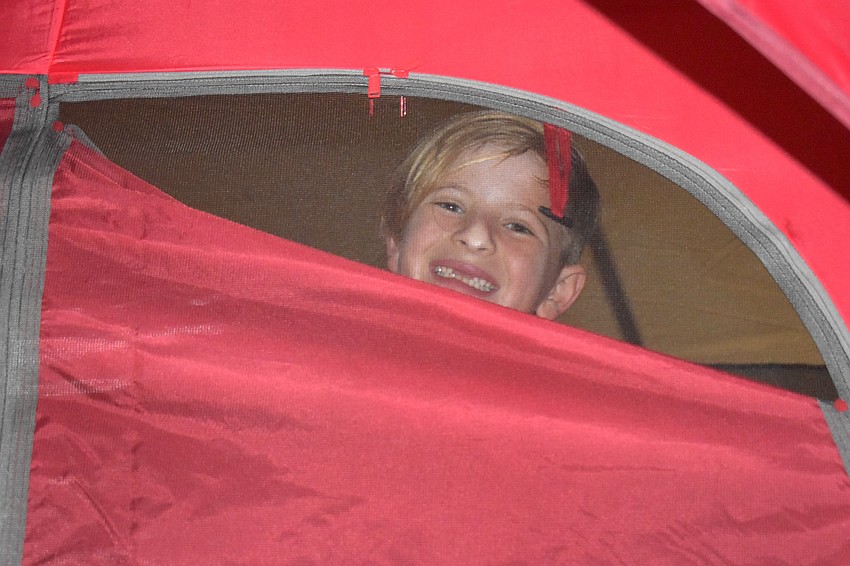 Lakewood Ranch's Holden Christoff, 8, settles into his tent where he will spend the night.