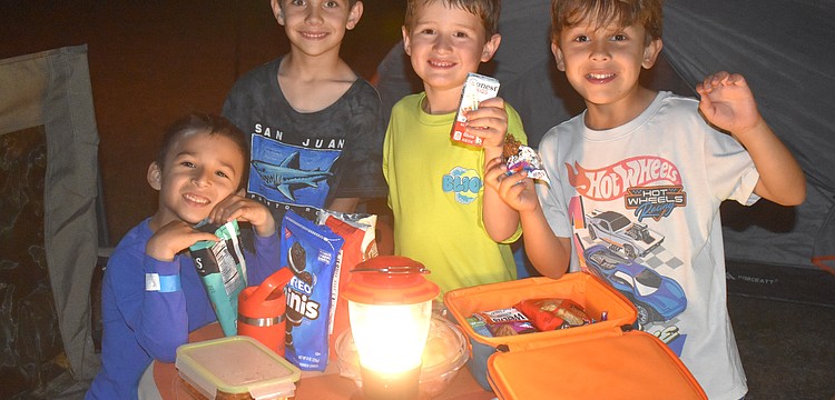 Nicholas Quintero, Conner King, Greyson Alexander and Lucas Matallana are campout ready with snacks, a lantern and even a headlamp.