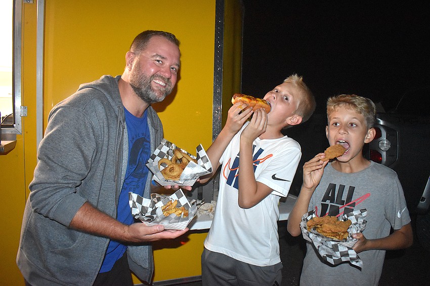 Chris Szymczakowski and his two sons, 11-year-old Mason and 10-year-old Jason, stop for a bite to eat at the Dawg Pound food truck.