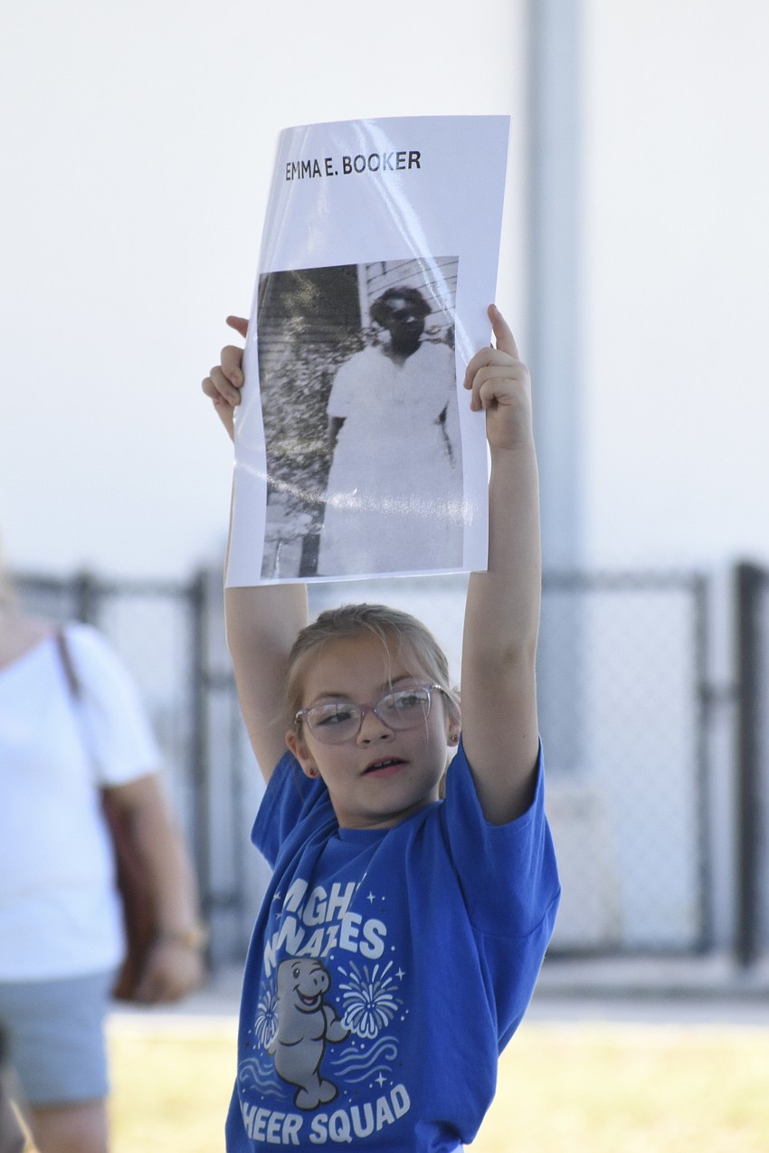 Fourth grader Sophia Roberts joined other students in holding banners during the event.