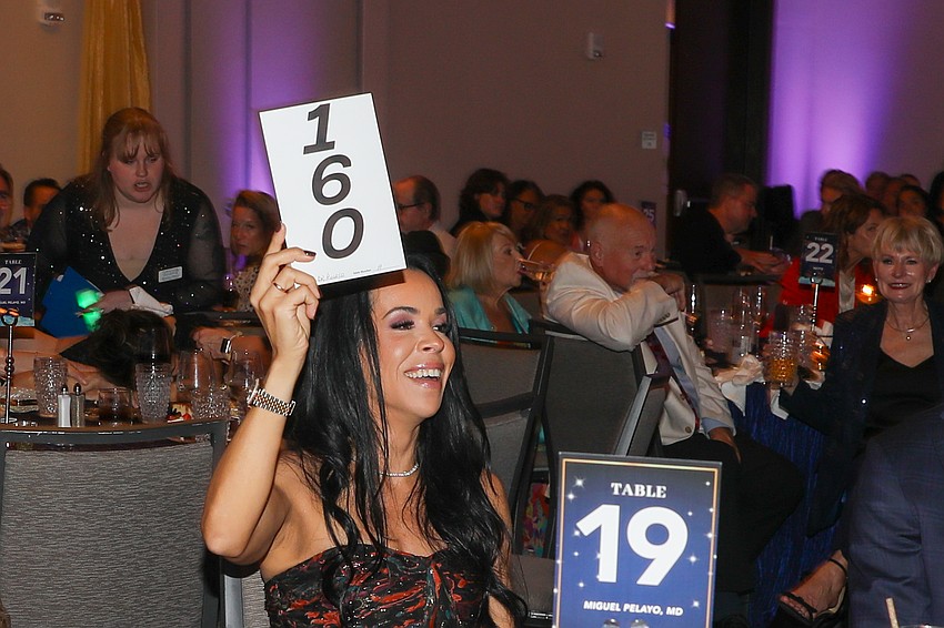 #160 Teresa Pelayo wins the first auction item of the night.