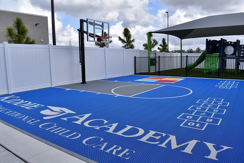 The playground features a multi-use athletic court.