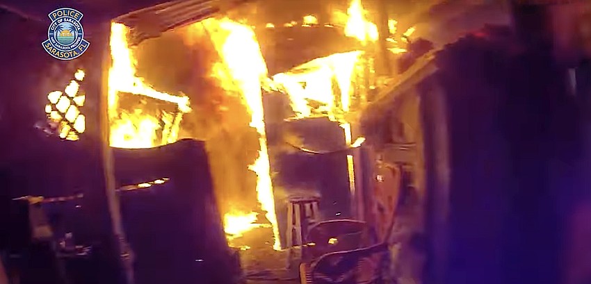 A home on North Osprey Avenue was fully engulfed in flames when Sarasota police officers entered to order everyone out and rescue two people inside, as shown by this body-worn camera image.
