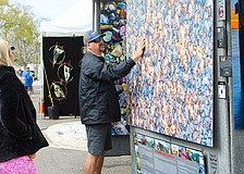 Gary Love of Gary Love Photography shows an art festival-goer how the various places the light hits the shell-covered beach give the up-close image depth. He was one of several new artists featured at the Feb. 21-22 art festival on Longboat Key.