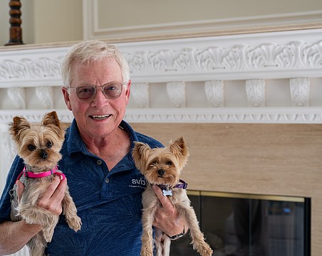 Longboat Key Mayor Ken Schneier holds Harriett (left) and Lizzie while posing for a picture in his Sabal Cove home Thursday, Feb. 19. After six years as mayor and eight on the Town Commission, Schneier has reached his term limit and will step down from the dais in March.