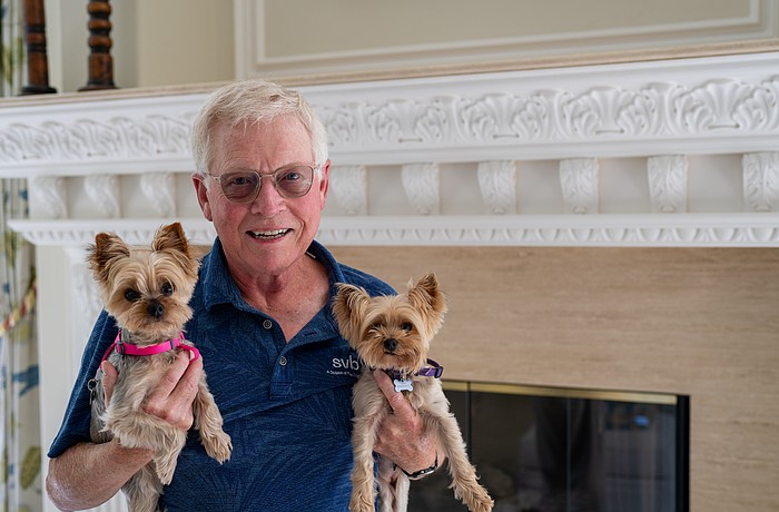 Longboat Key Mayor Ken Schneier holds Harriett (left) and Lizzie while posing for a picture in his Sabal Cove home Thursday, Feb. 19. After six years as mayor and eight on the Town Commission, Schneier has reached his term limit and will step down from the dais in March.