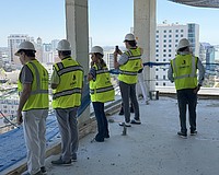 Real estate agents peer over a balcony on the 15th floor during a tour of the One Park condominium tower.