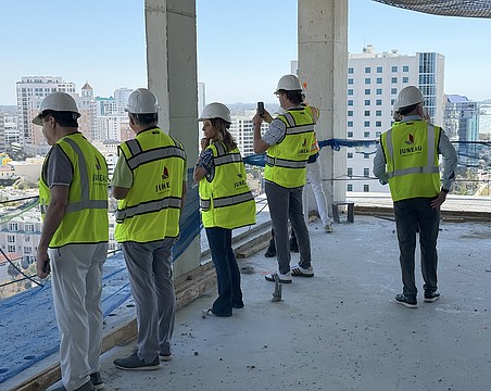 Real estate agents peer over a balcony on the 15th floor during a tour of the One Park condominium tower.
