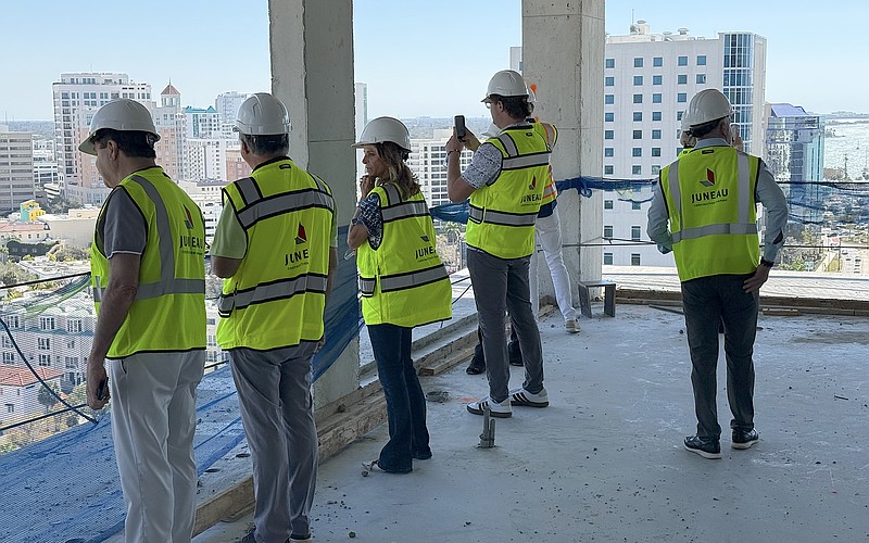 Real estate agents peer over a balcony on the 15th floor during a tour of the One Park condominium tower.