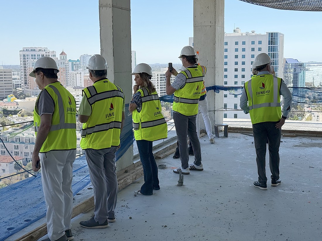Real estate agents peer over a balcony on the 15th floor during a tour of the One Park condominium tower.
