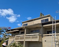 Firefighters break a hole in the roof of a building minutes after first responders extinguished the flames that engulfed a three-story residence devastated by what is reported as a potential electrical fire Monday, Feb. 23.