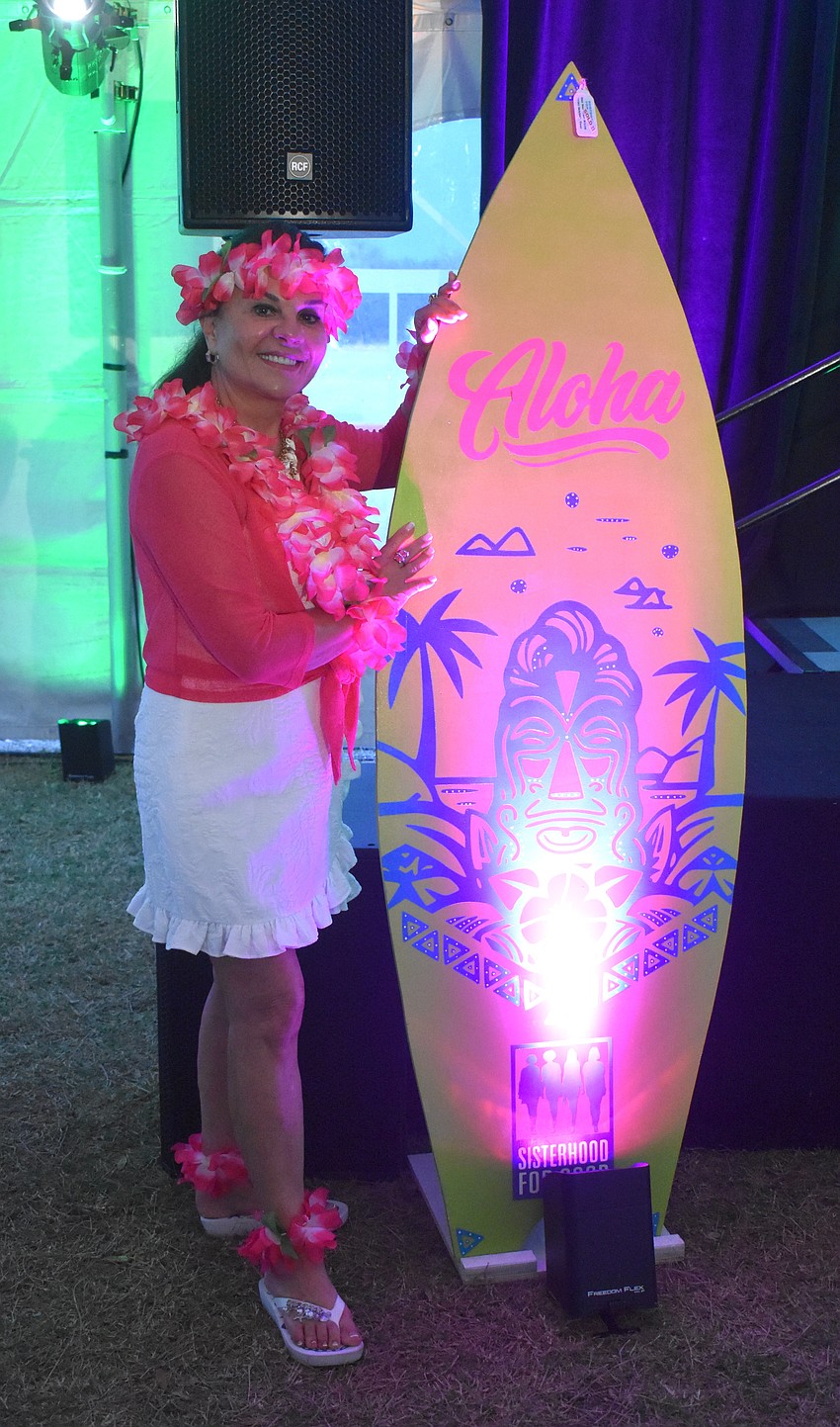 Country Club's Debi Wheeler accessorizes her outfit with leis from head to toe at the Tropical Escape event by Sisterhood for Good.