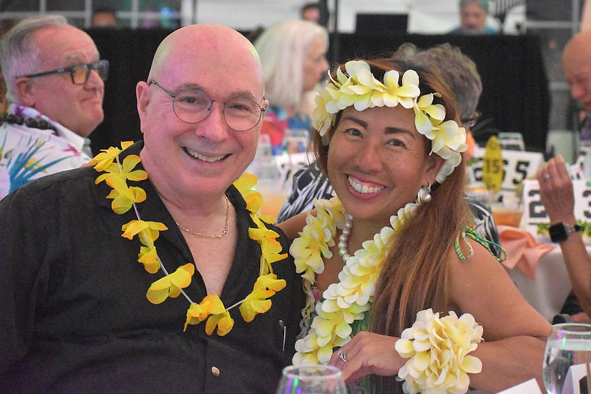 Joe Martinez, who booked the entertainment, and Debbie White, who taught Hawaiian dance moves prior to the event, enjoy the festivities at the Tropical Escape fundraiser by Sisterhood for Good.