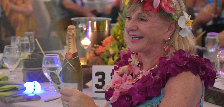 University Park's Marilyn Kern reacts after making the winning bid during the live auction for a Hawaiian vacation at Sisterhood for Good's Tropical Escape Feb. 27 at the Sarasota Polo Club.