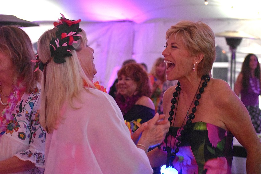 Starla Armstrong and Angela Massaro-Fain share a moment of joy on the dance floor at the Tropical Escape fundraiser for Sisterhood for Good.