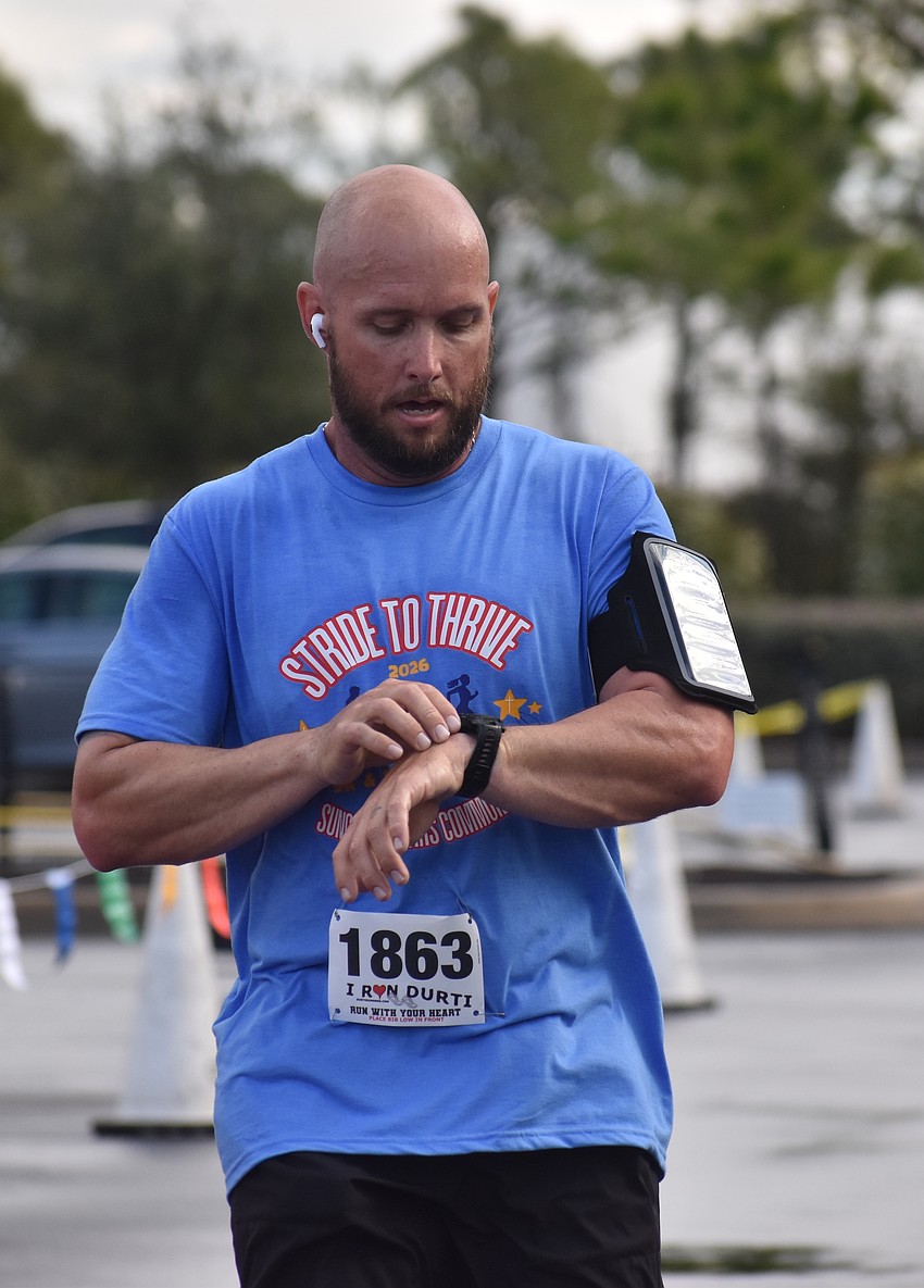 Sarasota's Kurt Chupp checks his watch as he finishes the race with a time of 20:13.