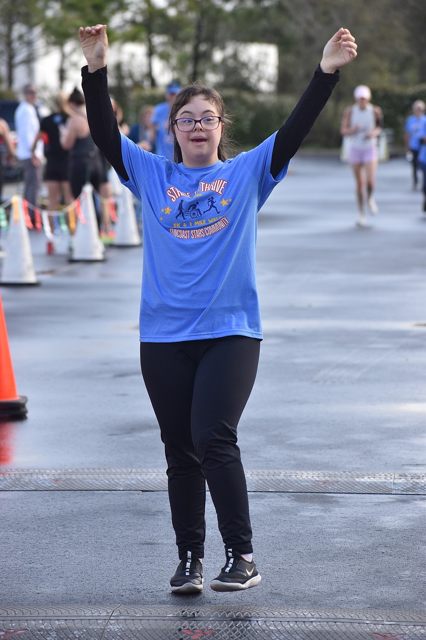 East County's Camila Braga, a member of the Suncoast Stars Community, celebrates as she crosses the finish line at the nonprofit's second annual Stride to Thrive 5K.